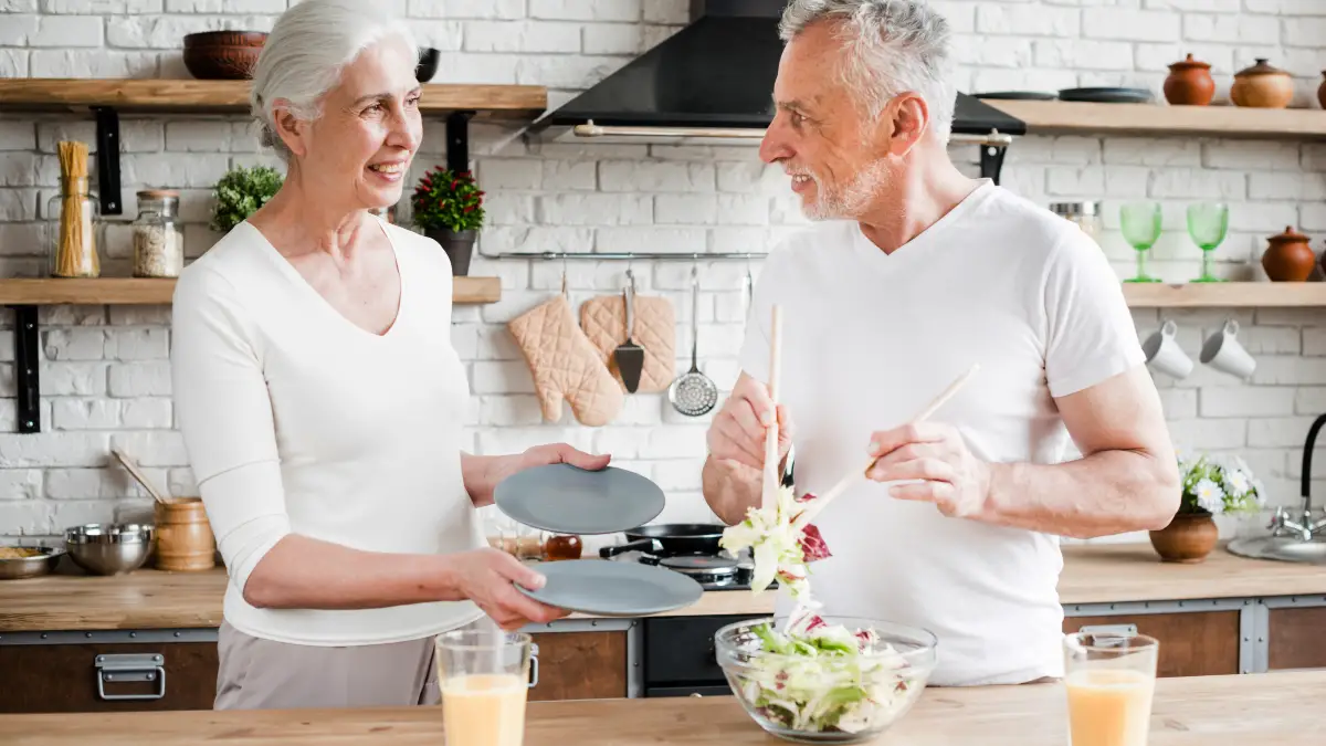 Active mature couple preparing a nutrient-dense meal to support metabolic heat production and healthy aging after 50.