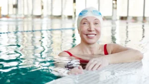 Mature woman standing in a therapeutic pool to find knee osteoarthritis pain relief through low-impact movement.