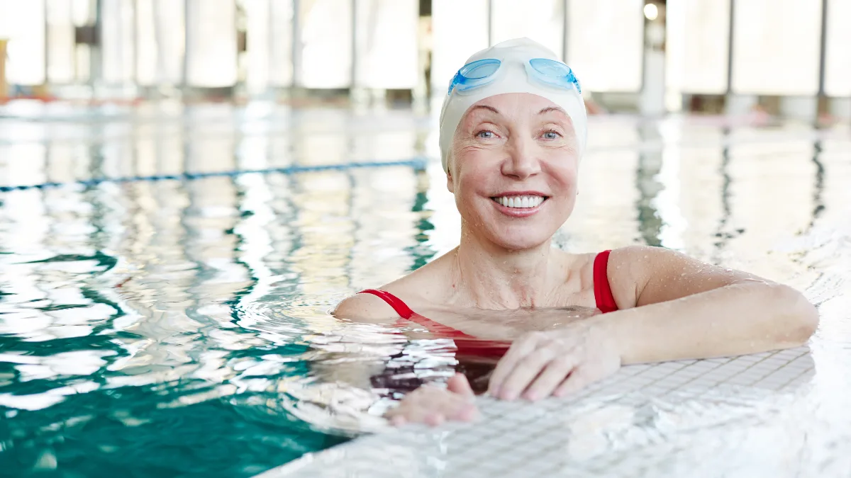 Mature woman standing in a therapeutic pool to find knee osteoarthritis pain relief through low-impact movement.