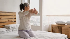 Mature woman performing a gentle morning stretch protocol to ease joint stiffness after 50