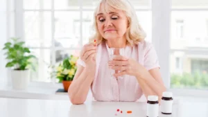 Mature woman taking daily supplements to support bone density after 50 and improve calcium absorption.