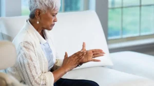 Mature woman rubbing her cold hands together to stimulate circulation and manage nitric oxide after 50.