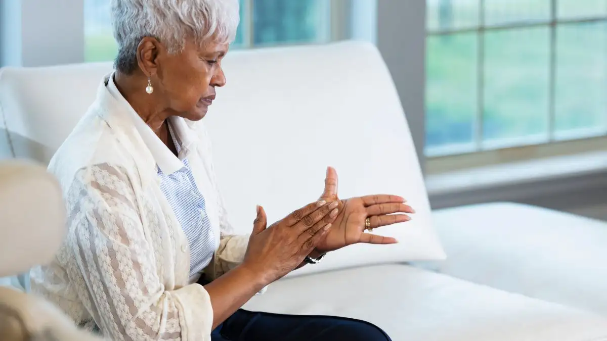 Mature woman rubbing her cold hands together to stimulate circulation and manage nitric oxide after 50.
