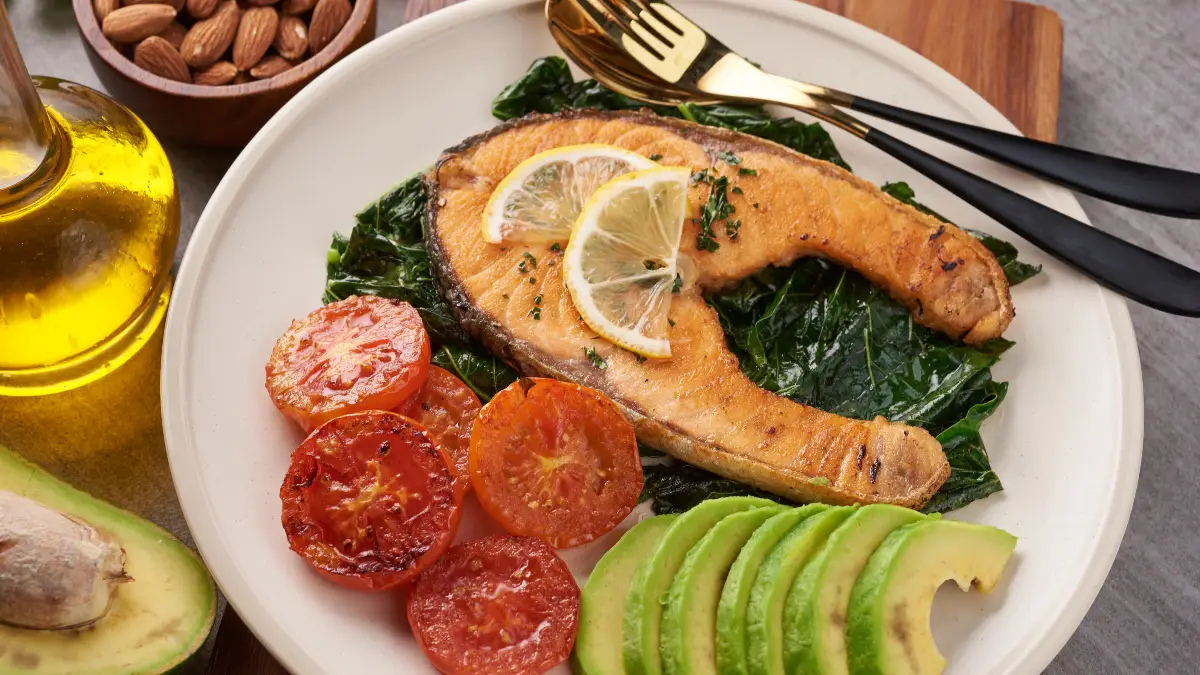 A Mediterranean-style meal with grilled salmon and healthy fats to manage basal metabolic rate and reduce systemic inflammation.