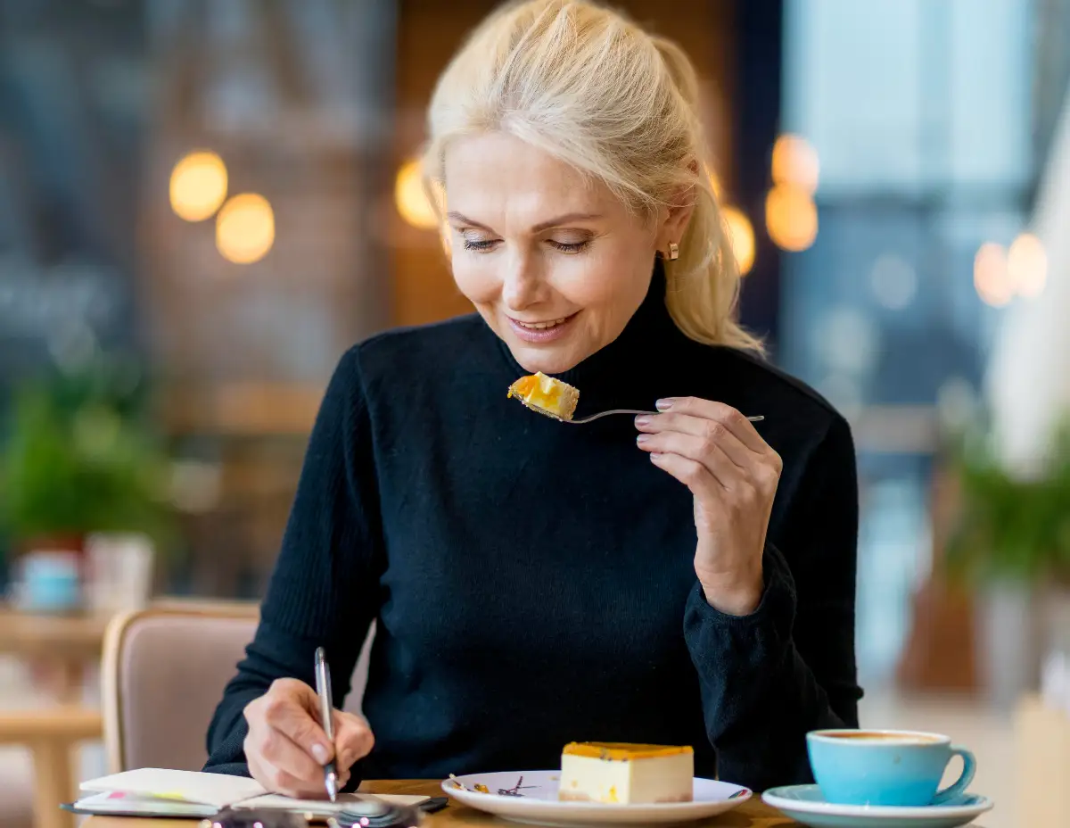 Mature woman tracking her feeding window in a planner to manage insulin resistance and metabolic health after 50.
