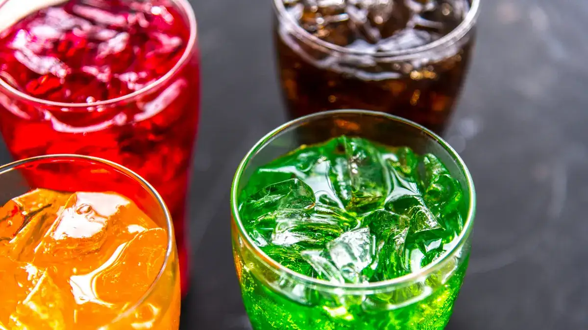A variety of brightly colored sugar-sweetened beverages with ice, illustrating the types of drinks linked to cellular aging.