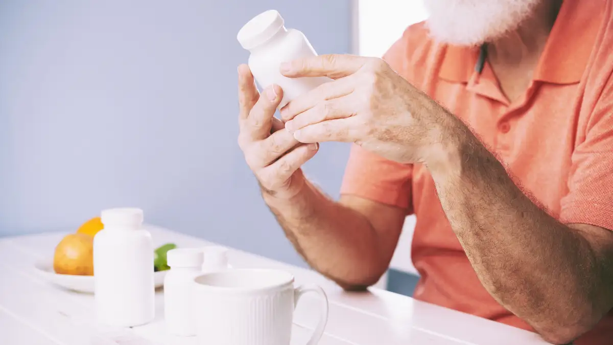 Mature man taking a probiotic supplement with a high-fiber meal to improve his basal metabolic rate.