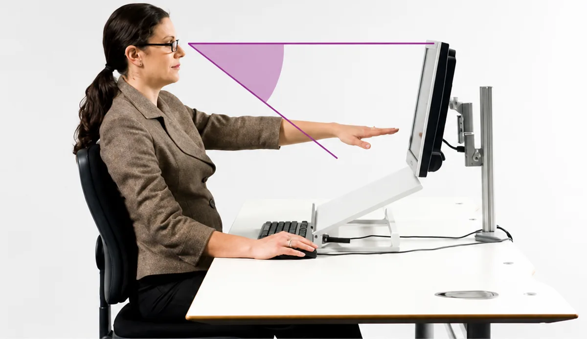 Woman at desk pointing toward monitor with purple angle graphic illustrating the 20-20-20 eye strain rule for screen users.
