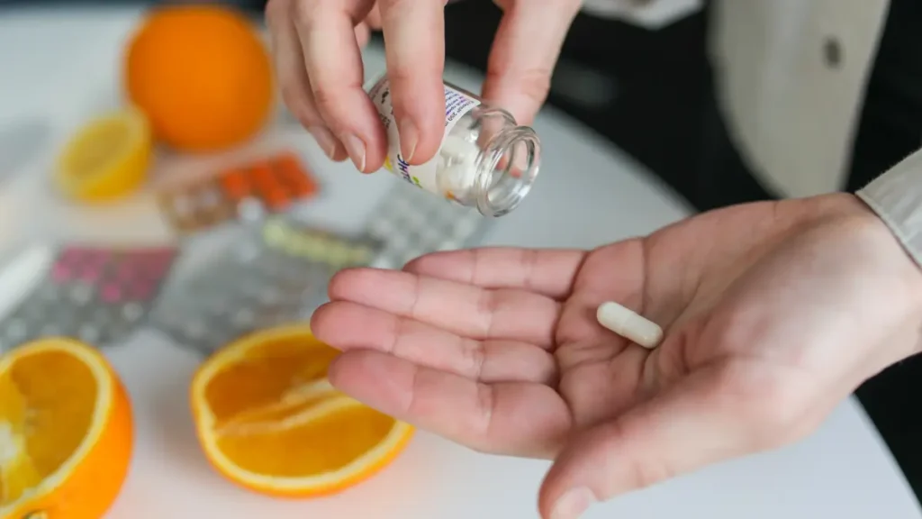Hand pouring a vitamin K2 supplement to support bone density as part of a nutritious morning routine for adults over 50.