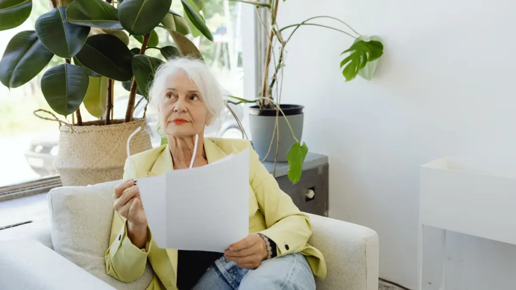 Senior woman reviews lab report with a thoughtful look, questioning if her TSH results match her age-related normal range.