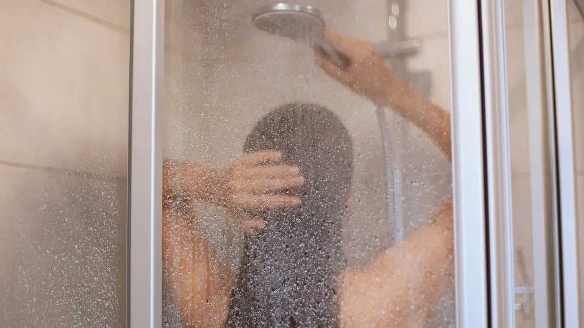 Steamy warm shower seen through a frosted glass door, illustrating how morning heat helps reduce fascial stiffness and improve mobility.