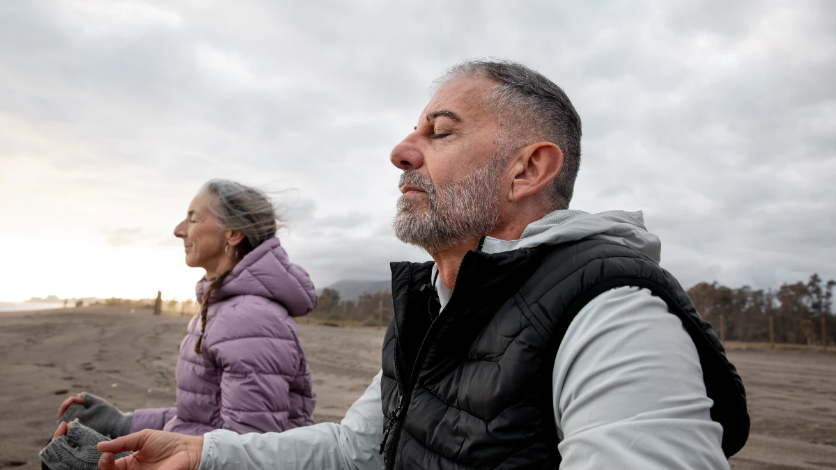 Mature couple practicing the 4-7-8 breathing technique outdoors to stimulate the vagus nerve and reduce stress through focused respiration.