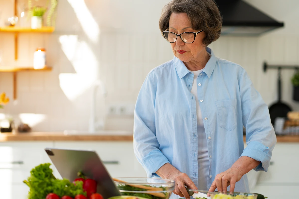 Mature woman preparing a gut-healthy breakfast to support ATP cellular energy and digestive vitality.