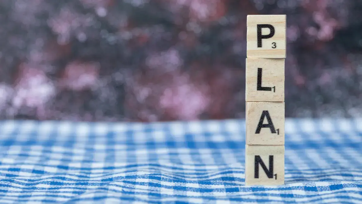 4-week knee exercise plan represented by stacked scrabble tiles spelling PLAN.
