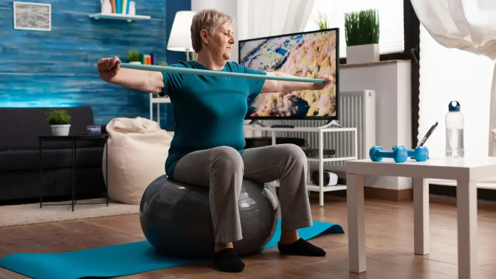 A senior woman doing resistance band exercises at home, showing how consistent training helps reduce chronic inflammation after 50.