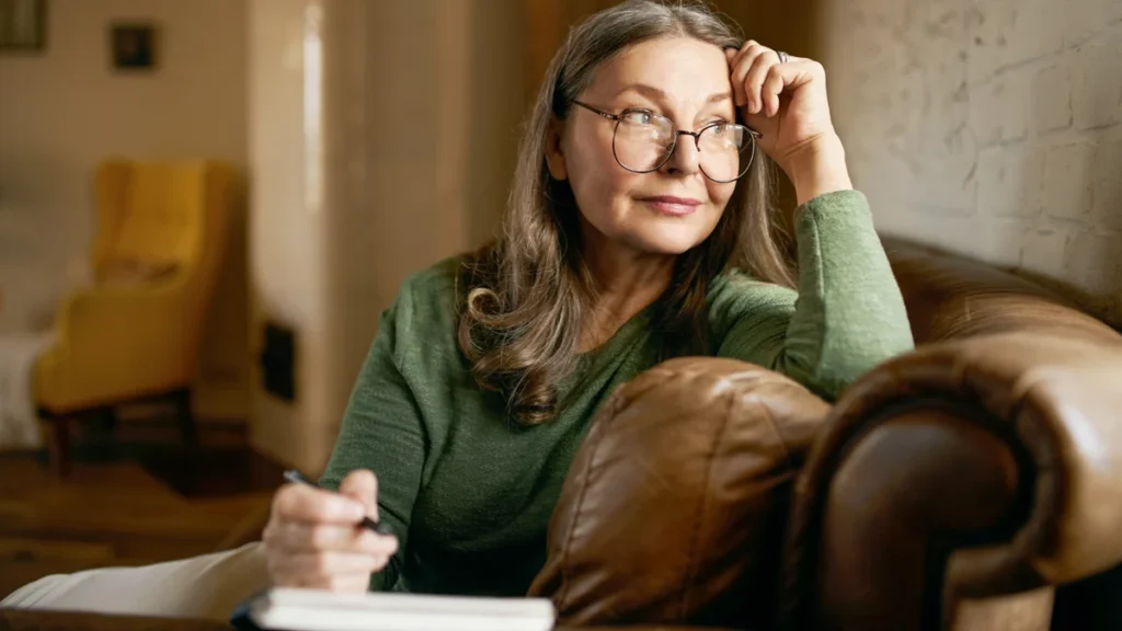 Thoughtful mature woman considering her daily medication routine in a quiet home setting.