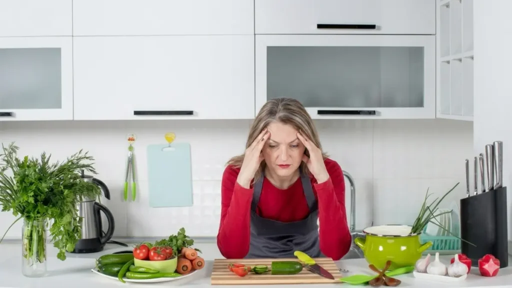 woman over 50 frustrated in kitchen struggling with morning hunger and metabolism changes.