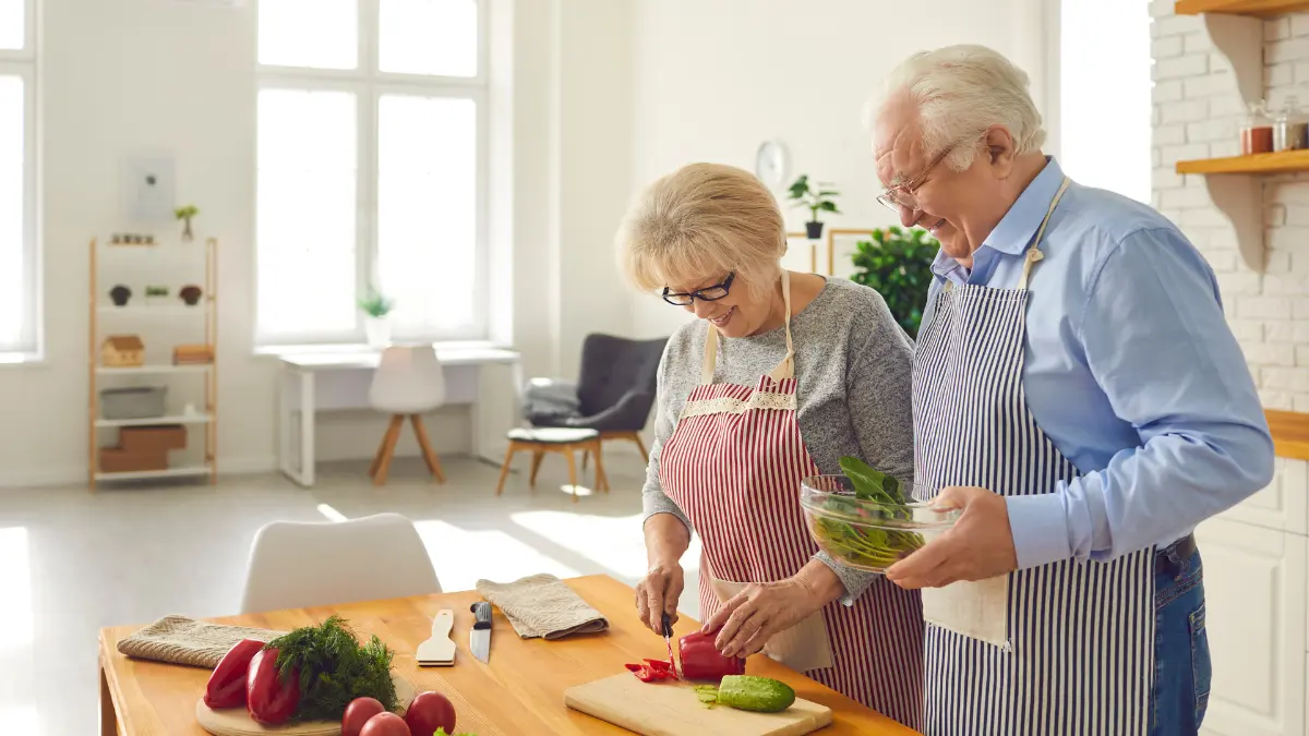 Older couple preparing healthy dairy-free calcium-rich foods in their kitchen to support bone health and aging well after 50