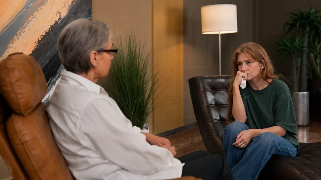 Mature woman speaking openly with a supportive therapist during a private cognitive behavioral therapy session.
