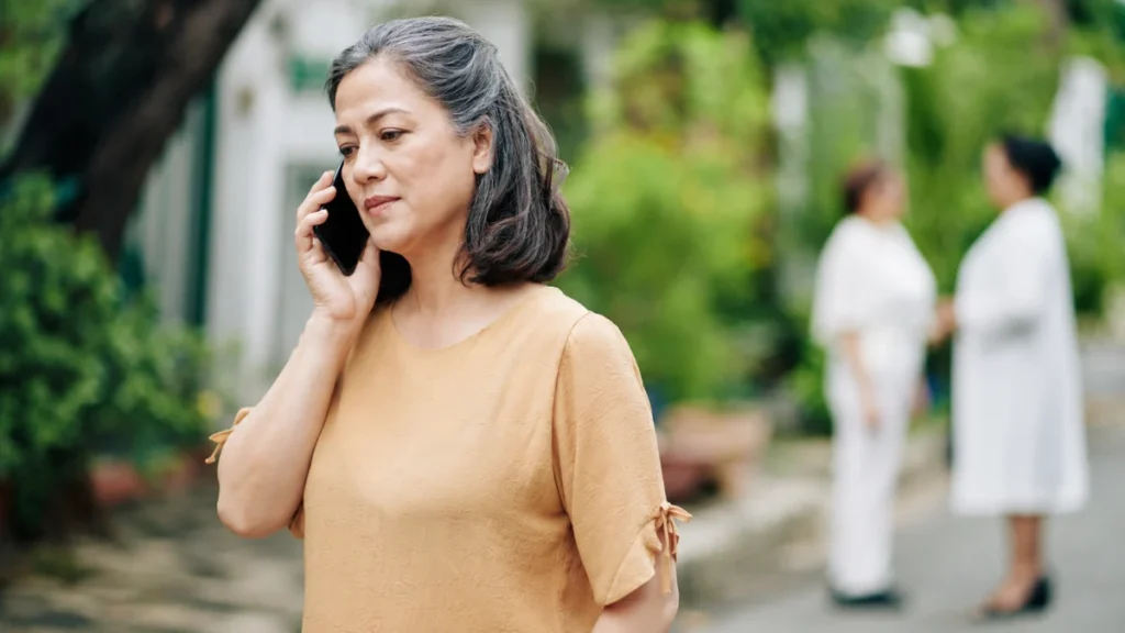 Older woman pausing mid-route during a phone call, illustrating the brain's response to dual-task demands.