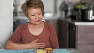 Mature women at the breakfast table, visibly uncomfortable with bloating after meals despite no change in diet