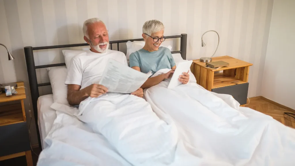 Older couple following a relaxing bedtime routine in a calm bedroom to support consistent sleep habits and deep sleep after age 50.