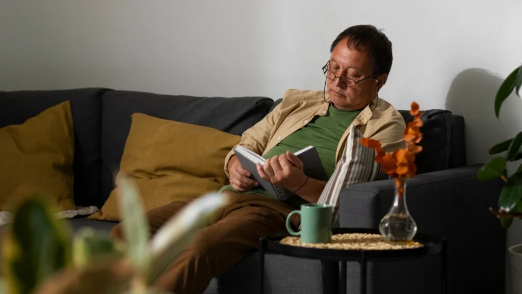 Retiree enjoying quiet solo time alone with a book and coffee.
