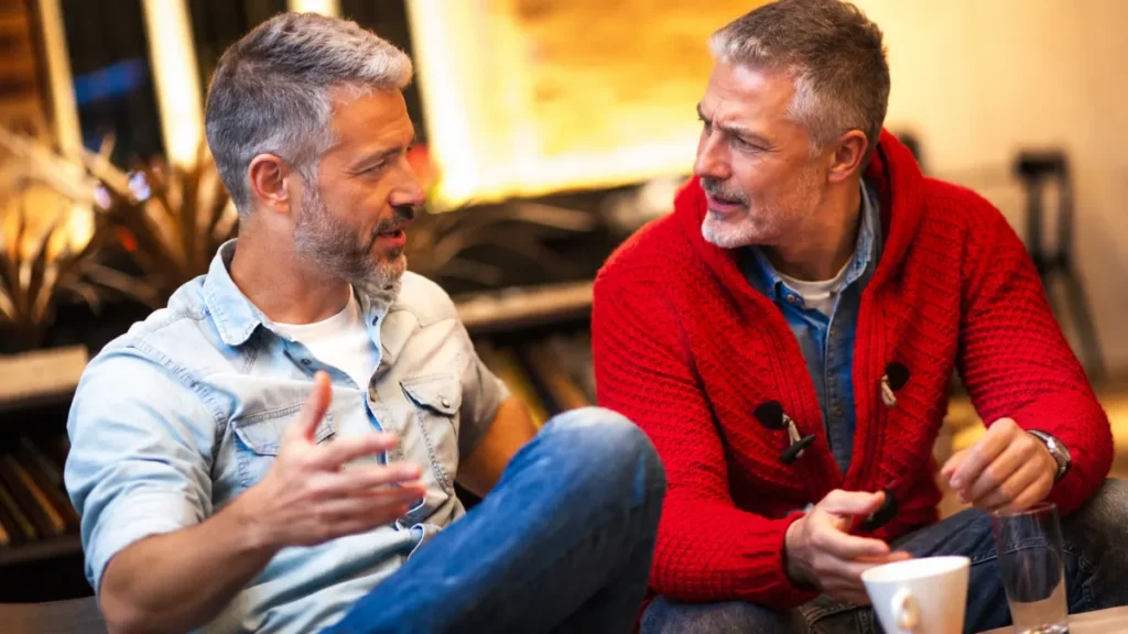 Two seniors in an animated, engaged discussion over coffee