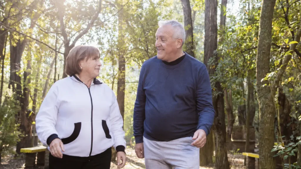 Active older couple walking briskly outdoors and talking, the everyday brain and heart vitality that EPA and DHA help support.